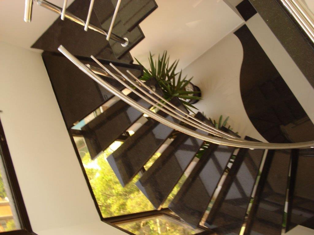 escada metálica curva com granito preto